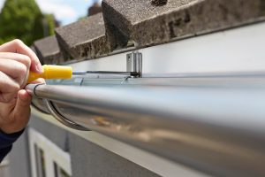 Person Cleaning Gutters